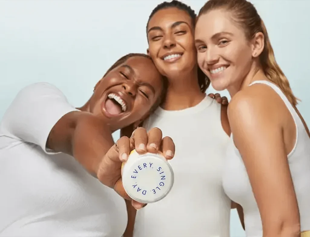 Happy Supergoop! customers holding a sunscreen container labeled “Every. Single. Day.”